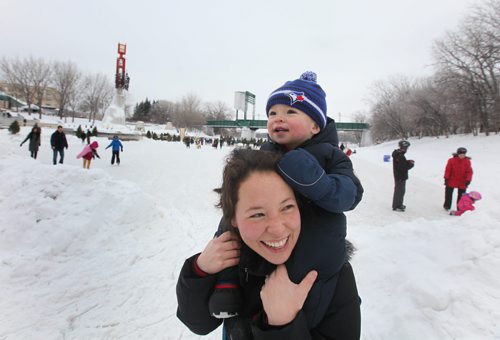 Fourteen month old Owen Wilkinson watches a train go over the train bridge while being carried on his mom's shoulders on the new Red River Mutual Trail on the Assiniboine River at the Forks Saturday afternoon.  Hundreds of  Winnipegers made their way down to the river to enjoy the newly opened river trail and the balmy winter weather.  Jan 11,, 2014 Ruth Bonneville / Winnipeg Free Press