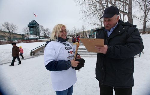 Ted  Hiebert signs a petition to keep door to door letter delivery service that Canada Post Letter Carrier Cheri Villard  was offering to visiter's at The Forks Market  Saturday afternoon. Jan 11,, 2014 Ruth Bonneville / Winnipeg Free Press