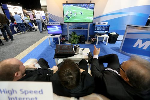 Exhibitors take a load off and watch some football in the MTS display at the Kitchen, Bath and Renovation Show at the Winnipeg Convention Centre, Saturday, January 11, 2014. (TREVOR HAGAN/WINNIPEG FREE PRESS)