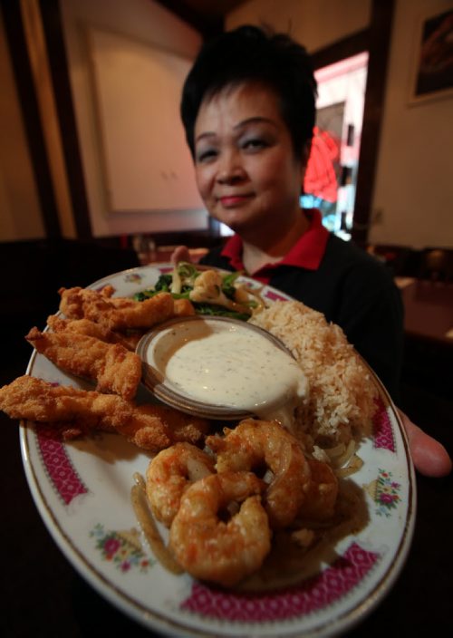 49/8 INTERSECTION - honey dill sauce Shirley Eng holds a platter of shrimp and chicken with her Honey Dill dipping sauce at Mitzi's Chicken Fingers -  What: This is for an Intersection feature on honey dill sauce, a Manitoba-centric dipping sauce that nobody outside the province seems familiar with. Mitzi's has been serving its homemade honey dill sauce for almost 30 years, alongside its world-famous chicken  fingers. So shot of owner Shirley holding up a plate of chicken fingers with a bowl of sauce for dipping... (might be good to get a second shot of the industrial-sized pails of sauce the restaurant stores its honey dill in, 'til they run out & have to slap See story. January 15, 2014 - (Phil Hossack / Winnipeg Free Press)