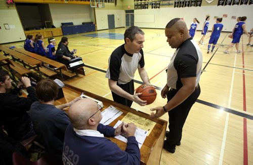 Basketball referee's Wayne Banfield (right) and Stewart McKenzie travel rural manitoba regularly in all types of weather to officiate matches in high school gyms. Here they check the game ball before starting a match between Carman's Cougars and the Gretna Blues. See Nick Martin story. January 14, 2014 - (Phil Hossack / Winnipeg Free Press)