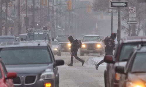 Pedestrians cross Portage Avenue at Fort Street Thursday morning despite the high winds and blowing snow. 140116 - January 16, 2014 MIKE DEAL / WINNIPEG FREE PRESS