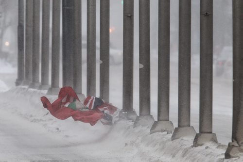 A provincial flag is tossed about after coming loose from its moorings at Portage Avenue and Main Street Thursday morning. 140116 - January 16, 2014 MIKE DEAL / WINNIPEG FREE PRESS
