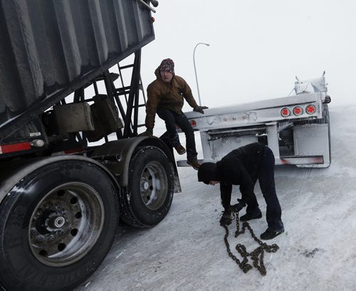 Stdup - Josh Bowland  and (right) Regina Prokopchuk help out fellow trucker  stuck in the parking lot of  truck stop at McGillivray Bld and Perimter Hwy 100 , they pulled the semi  truck out with theirs , they are on their way to Edmonton today Stdup Weather Äì high winds and blowing snow  are causing white out conditions on the Perimeter Hwy and open area coming into town causing many cars to go off the road  . JAN. 16 2014 / KEN GIGLIOTTI / WINNIPEG FREE PRESS