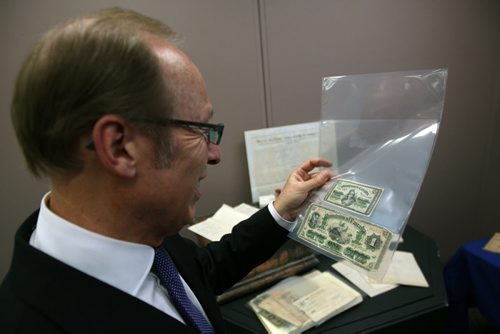 Mayor Sam Katz looks at old paper currency found in a time capsule- The items will be on display soon that show the early beginnings of Winnipeg as a city- See Randy Turner story- January 16, 2014   (JOE BRYKSA / WINNIPEG FREE PRESS)