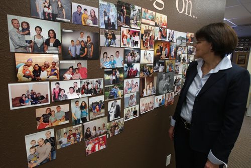 Winkler, Manitoba-Adele Dyck of Star 7 International, immigration brokerage firm that started the Provincial  Nominee Program in MB. Stands by wall of photos of potential immigrants-See Bill Redekop  story- Jan 14, 2014   (JOE BRYKSA / WINNIPEG FREE PRESS)
