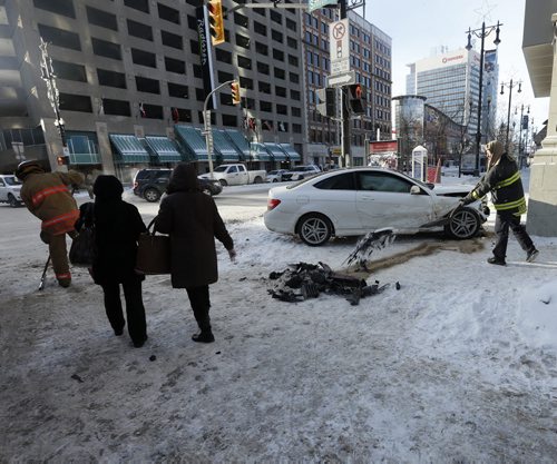 Wpg Fire Fighters clean up crash debris as pedestrian make their way around one of the damaged cars -MVC -Miraculously no one was injure when two car crashed into each other on Portage Ave at Smith St , air bags and side bags went off  and everyone was ok . JAN. 20 2014 / KEN GIGLIOTTI / WINNIPEG FREE PRESS