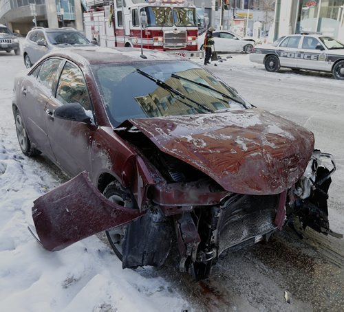 Wpg Fire Fighters clen up  crash debris -one car narrowly missing a building - MVC -Miraculously no one was injure when two car crashed into each other on Portage Ave at Smith St , air bags and side bags went off  and everyone was ok . JAN. 20 2014 / KEN GIGLIOTTI / WINNIPEG FREE PRESS