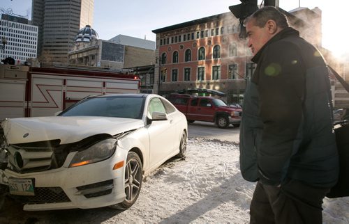Pedestrians were faced with an obstacles after a car ended up on the sidewalk at Portage Avenue and Smith Street. Monday morning. No serious injuries were reported in the two-car collision. 140120 - Monday, {month name} 20, 2014 - (Melissa Tait / Winnipeg Free Press)