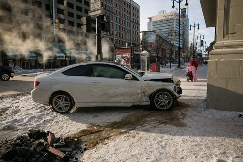 Pedestrians were faced with an obstacles after a car ended up on the sidewalk at Portage Avenue and Smith Street. Monday morning. No serious injuries were reported in the two-car collision. 140120 - Monday, {month name} 20, 2014 - (Melissa Tait / Winnipeg Free Press)