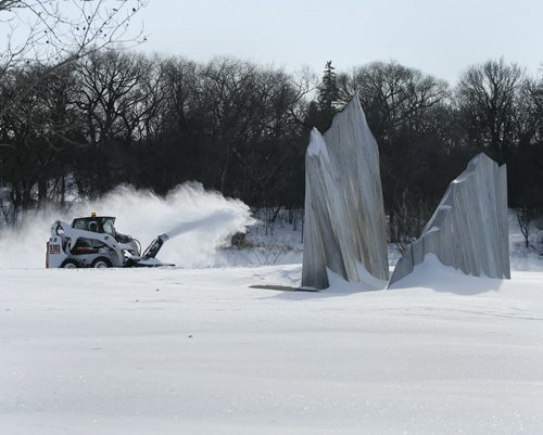 Stdup -  Artist Gordon Reeves , Agassiz Ice , a stainless steel  iceberg  at Assiniboine  Park near the foot bridge   was designed to keep in mind the prehistoric Lake Agassiz ice , with cold January  temps. no reminder was  needed today with a very real historic giant  snow thrower  clearing paths  for park visitors after last evening snow fall . JAN. 20 2014 / KEN GIGLIOTTI / WINNIPEG FREE PRESS
