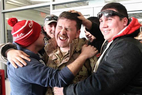 MBDR (Master Bombardier Nathan Cousineau from the 116 Independent Field Battery out of Kenora is greeted by friends Shaun Magill (left) and Kevin Weirsema (right) after arriving in Winnipeg at 17 Wing from Afghanistan. About 11 soldiers landed in Winnipeg after serving several months on Canada's final commitment to Operation ATTENTION, Canada's contribution to the International Assistance Force / NATO Training Mission in Afghanistan. 140120 - January 20, 2014 MIKE DEAL / WINNIPEG FREE PRESS