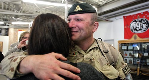 Sgt David Chelkowski with the 1st RCHA is greeted by his wife Jennifer after arriving in Winnipeg at 17 Wing from Afghanistan. About 11 soldiers landed in Winnipeg after serving several months on Canada's final commitment to Operation ATTENTION, Canada's contribution to the International Assistance Force / NATO Training Mission in Afghanistan. 140120 - January 20, 2014 MIKE DEAL / WINNIPEG FREE PRESS