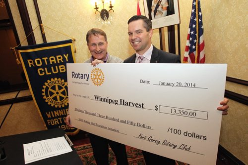 Jarrett Davidson (right) past president of the Fort Garry Rotary Club - Winnipeg, presents a cheque to David Northcott and Harvest Winnipeg for $13,350. The money was raised during the 2013 Rotary Half Marathon.  140120 January 20, 2014 Mike Deal / Winnipeg Free Press