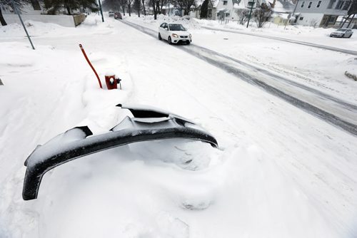 Stdup Äì Winnipeg roads are again snow covered with 5ft snow banks adorned with auto parts left over from the attrition of MVC's  along the cities roadways , this bumper on Burrows Ave at Parr St.- JAN. 21 2014 / KEN GIGLIOTTI / WINNIPEG FREE PRESS