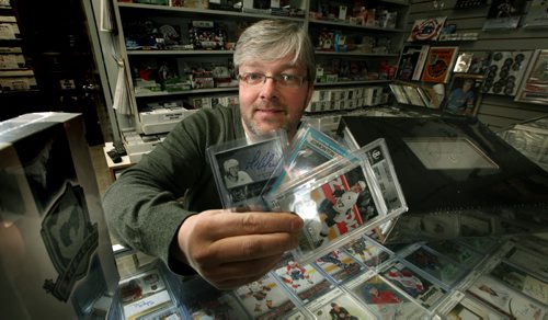 This week's Money Matters looks at the financial side of collecting hockey cards. It's not just old cards that fetch a pretty penny these days. There's a new generation of high-end collectors' cards that are worth more than $100 a pack, and if you're lucky enough to find a would-be superstar rookie among the five or so cards in the pack, you could be holding in your hand a collectable worth thousands. Kyle Franklin, owner of Superstar Sports shows off some examples of the new premium cards. See story. January 21, 2014 - (Phil Hossack / Winnipeg Free Press)