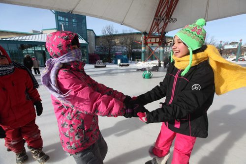 Students from Tyndall Park Community School have some fun on the ice after taking part in an educational day at the Forks learning about Aboriginal culture Thursday.  The students dressed for the weather but had limited time outside due to the cold temperatures. Standup Photo. Names of girls - Aliya Santos - left and Arzo Sayeed in green hat on right.   Jan 22,, 2014 Ruth Bonneville / Winnipeg Free Press
