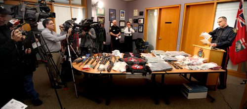 City Police Sgt. Max Waddell (right) shows off a table of evidence, confiscated from the Manitoba Warriors by police today at the morning police media briefing. See story. January 24, 2014 - (Phil Hossack / Winnipeg Free Press)