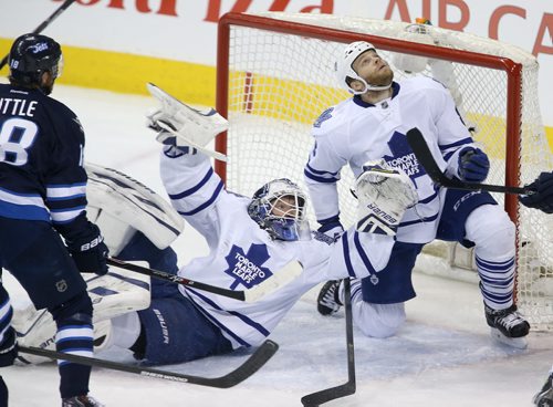 Winnipeg Jets' Bryan Little (18) in front of the Toronto Maple Leafs' net as Leafs' goaltender James Reimer (34) and Tim Gleason (8) look for a deflected puck during first period NHL hockey action at MTS Centre in Winnipeg, Saturday, January 25, 2014. (TREVOR HAGAN/WINNIPEG FREE PRESS)