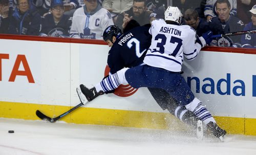 Winnipeg Jets' Adam Pardy (2) and Toronto Maple Leafs' Carter Ashton (37) battle for the puck during first period NHL hockey action at MTS Centre in Winnipeg, Saturday, January 25, 2014. (TREVOR HAGAN/WINNIPEG FREE PRESS)