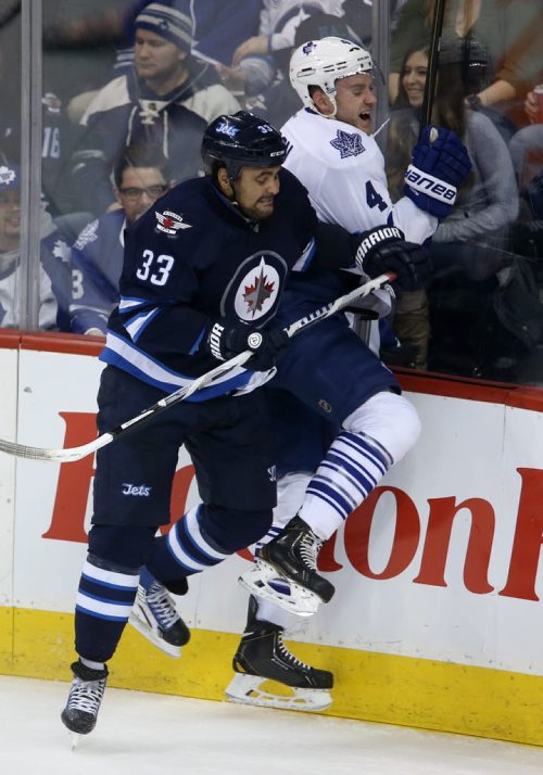 Winnipeg Jets' Dustin Byfuglien (33) crushes Toronto Maple Leafs' Cody Franson (4) into the boards during first period NHL hockey action at MTS Centre in Winnipeg, Saturday, January 25, 2014. (TREVOR HAGAN/WINNIPEG FREE PRESS)