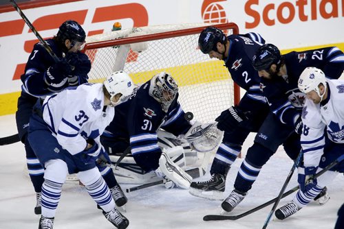 Winnipeg Jets' goaltender Ondrej Pavelec (31) makes a tricky sae with a crowd in front of him against the Toronto Maple Leafs' during first period NHL hockey action at MTS Centre in Winnipeg, Saturday, January 25, 2014. (TREVOR HAGAN/WINNIPEG FREE PRESS)