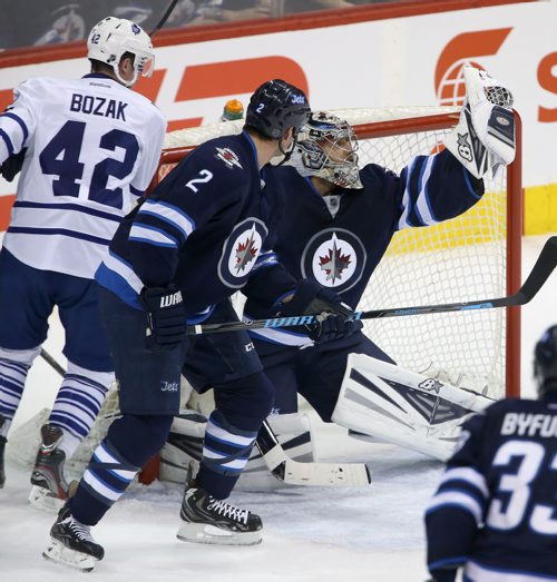 Winnipeg Jets' goaltender Ondrej Pavelec (31) flashes the leather with Toronto Maple Leafs' Tyler Bozak (42) and Jets' Adam Pardy (2) in front of the net during first period NHL hockey action at MTS Centre in Winnipeg, Saturday, January 25, 2014. (TREVOR HAGAN/WINNIPEG FREE PRESS)