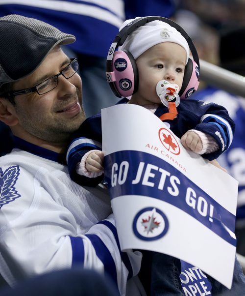 Adam Hagarty and Mayla Hagarty, 9 months, watching the Winnipeg Jets' play the Toronto Maple Leafs' during second period NHL hockey action at MTS Centre in Winnipeg, Saturday, January 25, 2014. (TREVOR HAGAN/WINNIPEG FREE PRESS)