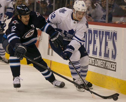 Jets' centre Oli Jokinen pressures Leafs' forward Mason Raymond behind the net during the third period at MTS Centre Saturday night. The Jets won in overtime 5-4. 140125 - Saturday, {month name} 25, 2014 - (Melissa Tait / Winnipeg Free Press)