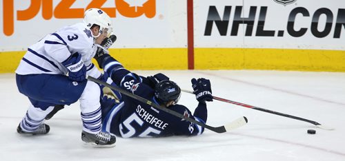 Winnipeg Jets' Mark Scheifele (55) lays on the ice after being tripped up by Toronto Maple Leafs' Dion Phaneuf (3) during third period NHL hockey action at MTS Centre in Winnipeg, Saturday, January 25, 2014. (TREVOR HAGAN/WINNIPEG FREE PRESS)