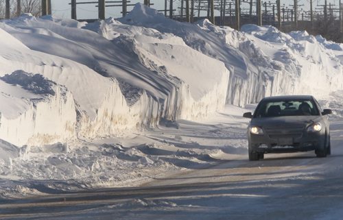 Snow Mountains- A car drives on Saskatchewan Ave in St James dwarfed by massive snow banks nearly 4 m high   standup photo- Jan 30, 2014   (JOE BRYKSA / WINNIPEG FREE PRESS)