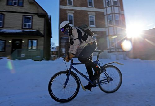 A cyclist rides up the sidewalk on Sherbrook Street, Thursday, January 30, 2014. (TREVOR HAGAN/WINNIPEG FREE PRESS)