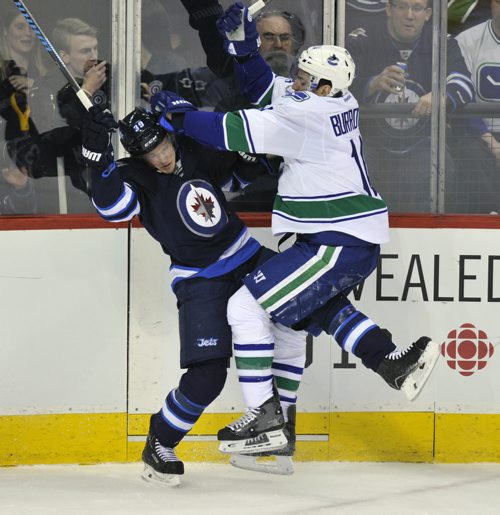 Winnipeg Jets Tobias Endstrom runs Vancouver h Canucks Alexandre Burrows  during first period NHL action in Winnipeg Friday night -See story- Jan 31, 2014   (Fred Greenslade  / Special for the WINNIPEG FREE PRESS)