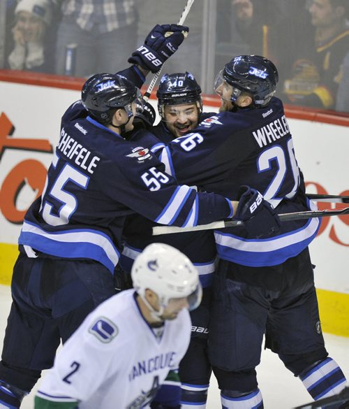 Winnipeg Jets  Devin Setoguchi is congratulated by teammates Mark Scheifele, left, and Blake Wheeler after scoring the game winning goal against the  Vancouver Canucks during Third period NHL action in Winnipeg Friday night  The Jets beat the Canucks 4-3-See story- Jan 31, 2014   (Fred Greenslade/ Special to the WINNIPEG FREE PRESS)