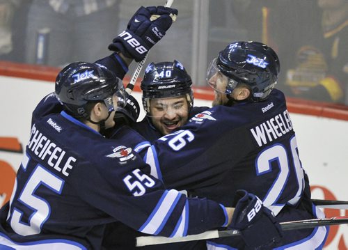 Winnipeg Jets  Devin Setoguchi is congratulated by teammates Mark Scheifele, left, and Blake Wheeler after scoring the game winning goal against the  Vancouver Canucks during Third period NHL action in Winnipeg Friday night  The Jets beat the Canucks 4-3-See story- Jan 31, 2014   (Fred Greenslade/ Special to the WINNIPEG FREE PRESS)