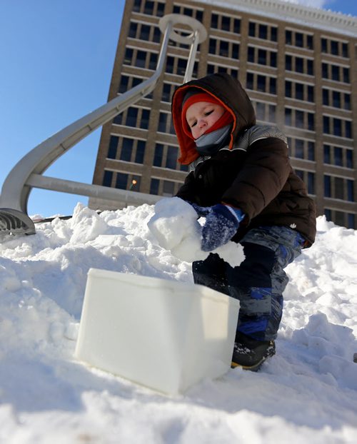 Jordan Bain, 2, works on a snow block at the Snow Maze being assembled at the Millennium Library, Saturday, February 1, 2014. (TREVOR HAGAN/WINNIPEG FREE PRESS)
