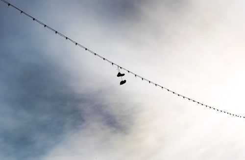 Shoes hang from a string of lights over Osborne St in the Village Tuesday- Standup Photo- Feb 04, 2014   (JOE BRYKSA / WINNIPEG FREE PRESS)