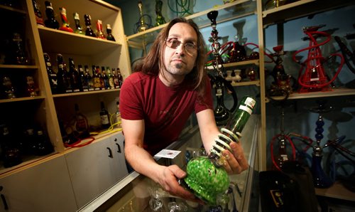 Hemp Haven owner Jeremy Loewen brandishes a bong Tuesday posing in his Watt Street store. He was raided by police last week and hasn't opened since. See story. February 4, 2014 - (Phil Hossack / Winnipeg Free Press)