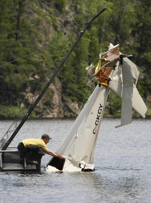 John Woods / Winnipeg Free Press / June 18/07- 070618  - Matt Walker ties a rope to the tail section of a small plane from West Hawk Lake Monday June 18/07.  RCMP removed the plane that crashed in West Hawk Lake Monday June 11/07.  Two men died in the crash.
