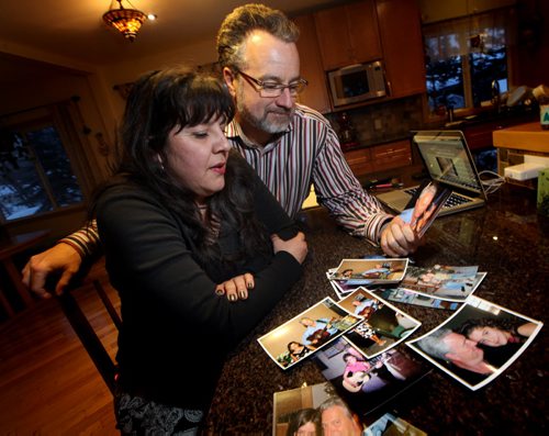 Eugenia and Sean Lehmann, the son and daughter-in-law of Les Lehmann in Dominican Republic who scared off home invaders with a bat and got shot 9 times in the process, they're posing at home with a number of family snapshots of Les. See Carol Sanders story. February 6, 2014 - (Phil Hossack / Winnipeg Free Press)