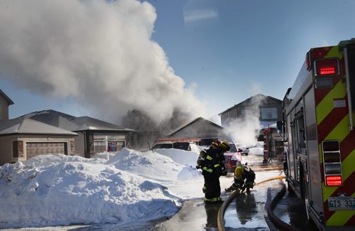 Firefighters in defensive mode move giant hoses that were feeding aerial ladder extinguishing a fire at a fire today on Ed Golding Bay in Transcona- The home is a total loss with officials pegging damage at $400,000-    See story- Feb 10, 2014   (JOE BRYKSA / WINNIPEG FREE PRESS)