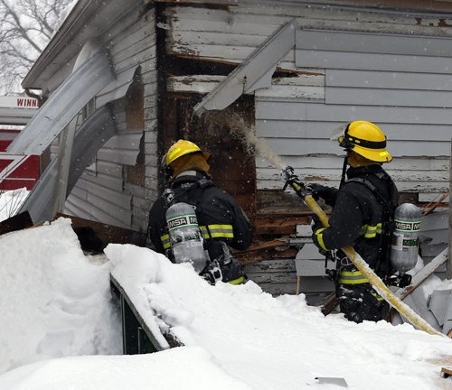 Fire fighters cut into rear walls to  spray exxtentions of the fire -House fire at 263 Union Ave West near Roch St. , one male occupant of the house was treated for smoke inhalation  , the fire is believed to have started at the rear of the home .FEB. 11 2014 / KEN GIGLIOTTI / WINNIPEG FREE PRESS
