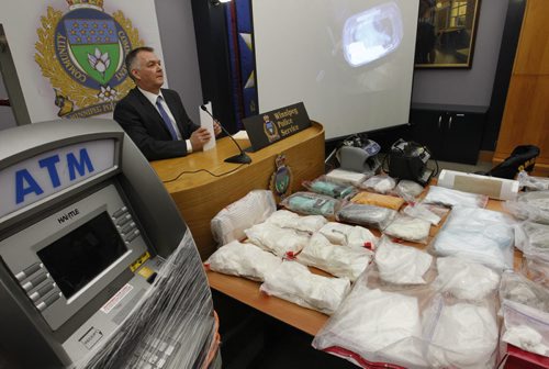 Winnipeg Police Staff Sgt. Rob Harding at a news conference Thursday with a sample of the items including a ATM machine, drugs and cash obtained from Project Sideshow.  A news release states in the spring of 2012 the Winnipeg Police Service Organized Crime Unit commenced Project Sideshow, targeting an Organized Crime Group that operates across Canada importing Cocaine, Methamphetamine and MDMA (Ecstasy) into Winnipeg for further distribution.¤  Wayne Glowacki / Winnipeg Free Press Feb. 13   2014