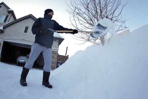 Darren Melanson shovels snow on Lyndale Drive. BORIS MINKEVICH/WINNIPEG FREE PRESS  Feb. 13/14