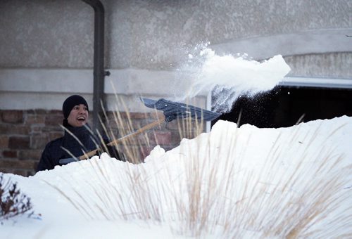 Darren Melanson shovels snow on Lyndale Drive. BORIS MINKEVICH/WINNIPEG FREE PRESS  Feb. 13/14