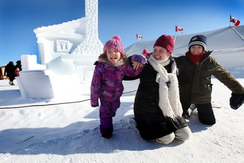 5 year old Monica Claire, her mom Elizabeth Whitaker-Jacques and her niece Tianna Govia -11yrs (on right)  goof around one of their favourite snow sculpture at the Festival du Voyageur Saturday afternoon. Feb 15,, 2014 Ruth Bonneville / Winnipeg Free Press