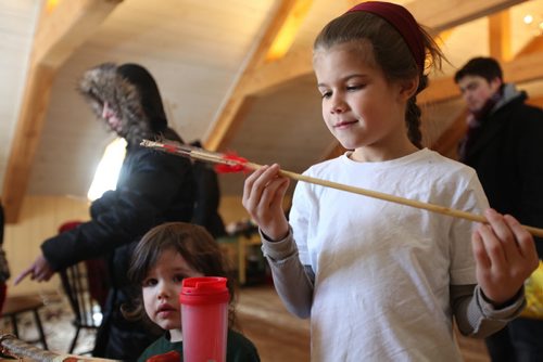 Eight year old Liam Greyeyes looks closely at a handcrafted arrow at as his little brother Alex looks on at one of the Festival workshops at the Festival du Voyageur Saturday.   Feb 15,, 2014 Ruth Bonneville / Winnipeg Free Press