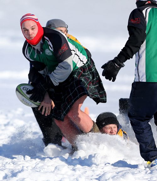 Daniel Dickson, wearing a kilt, of the Winnipeg Wanderers passes the ball during a game against the Winnipeg Saracens during the Winnipeg Wasps Snow 7's Annual Rugby Tournament on the intersection of the Red and Assiniboine Rivers, Saturday, February 15, 2014. (TREVOR HAGAN/WINNIPEG FREE PRESS)