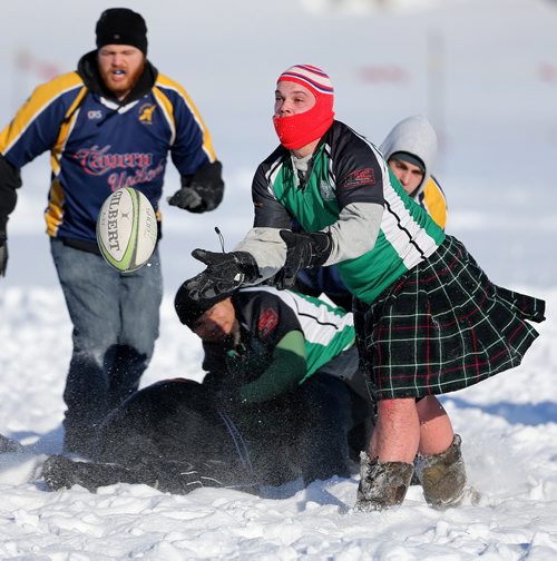 Daniel Dickson, wearing a kilt, of the Winnipeg Wanderers passes the ball during a game against the Winnipeg Saracens during the Winnipeg Wasps Snow 7's Annual Rugby Tournament on the intersection of the Red and Assiniboine Rivers, Saturday, February 15, 2014. (TREVOR HAGAN/WINNIPEG FREE PRESS)