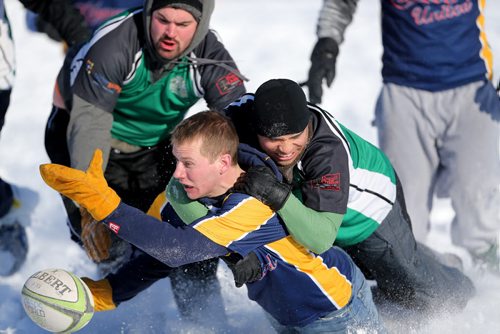 Kris Pritchard and John Rhoda of the Winnipeg Wanderers tackle Andrew Sheldon of the Winnipeg Saracens during the Winnipeg Wasps Snow 7's Annual Rugby Tournament on the intersection of the Red and Assiniboine Rivers, Saturday, February 15, 2014. (TREVOR HAGAN/WINNIPEG FREE PRESS)